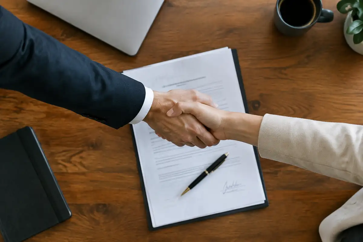 Poignée de main au-dessus d'un contrat signé