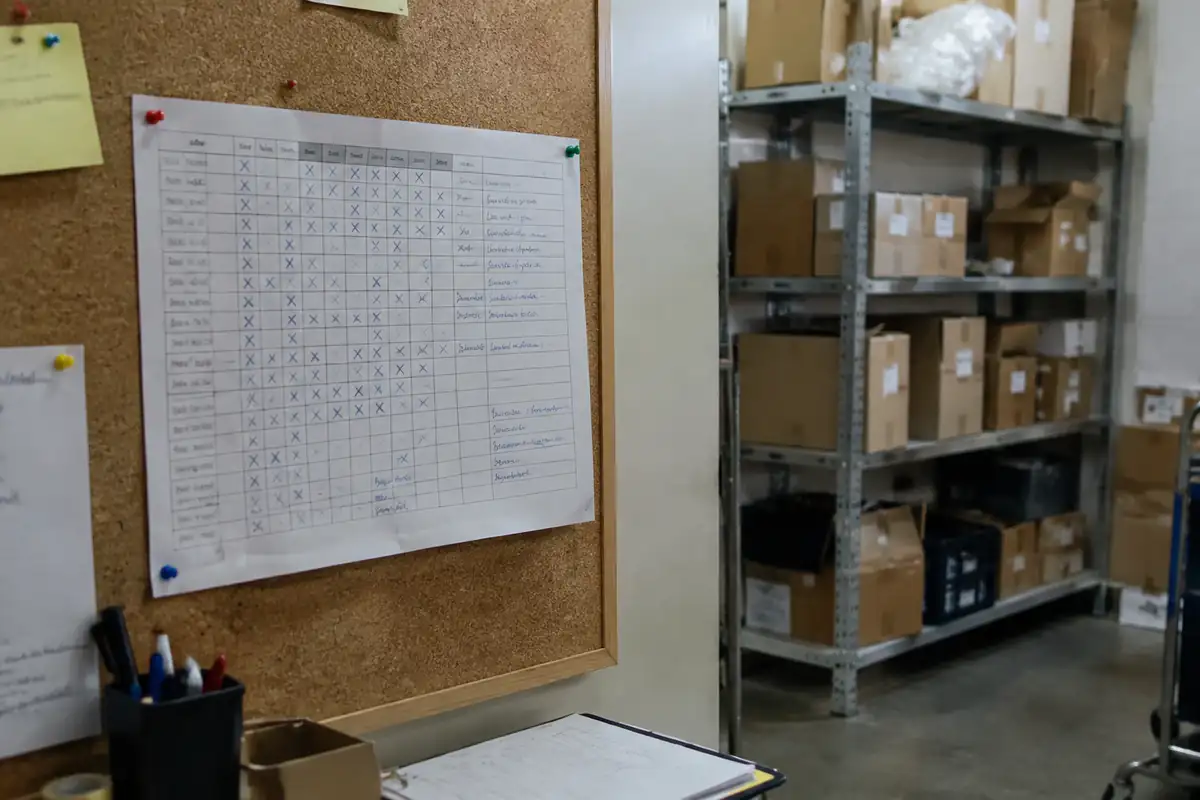 Planning papier épinglé sur un panneau dans l'arrière-boutique